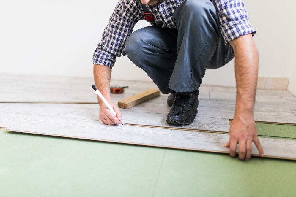 Young worker lining a floor with flooring boards